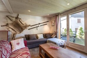 A cozy living room with a sofa, a wooden coffee table, and a mounted fur rug.