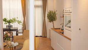 A modern apartment with a dining area, a kitchen, and a living space.