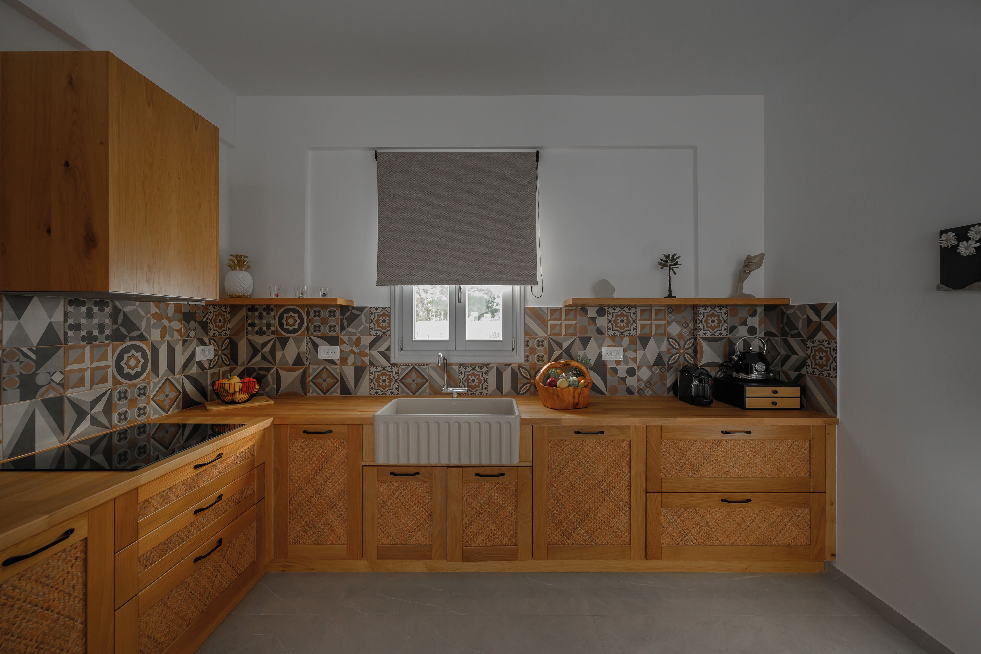 A kitchen with wooden cabinets, a sink, and patterned backsplash tiles.