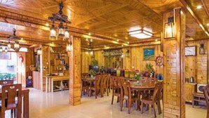 A wooden interior with a dining area, wooden walls, and ceiling fans. - Longji Rice Terraces Fengya Mountain Dwelling B&B (Longsheng)