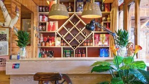 A wooden interior with a bar area, shelves with bottles, and a plant. - Longji Rice Terraces Fengya Mountain Dwelling B&B (Longsheng)
