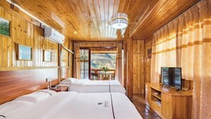 A wooden cabin-style room with two beds, a TV, and a dining area with a view of the outdoors. - Longji Rice Terraces Fengya Mountain Dwelling B&B (Longsheng)