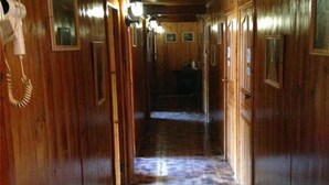A wooden hallway with doors and a telephone on the left. - Longji Rice Terraces Fengya Mountain Dwelling B&B (Longsheng)