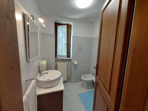 Un baño con lavamanos, inodoro y bidé.