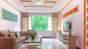 Una sala de estar moderna con sofá, mesa de centro, televisor y elementos decorativos.