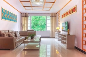 A modern living room with a sofa, coffee table, TV, and decorative items. - Ya'an River Lake April Inn (Ya'an)