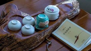 A wooden tray with teapots and a book on a table.