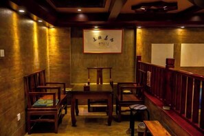 A traditional dining area with wooden furniture and a framed sign on the wall. - Boao Yingke Hotel (Dali City)