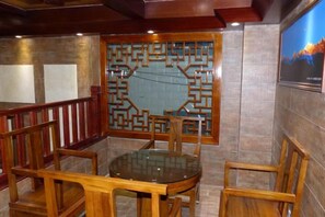 A room with a round table and four chairs, a decorative screen, and a framed picture on the wall. - Boao Yingke Hotel (Dali City)