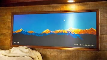 Un televisor montado en la pared con un paisaje de montaña.
