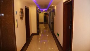 A hotel corridor with a polished floor, doors on either side, and a ceiling with purple lighting. - Lumingchun Hotel (Changbai Mountain North Scenic Area Distribution Center) (Antu)
