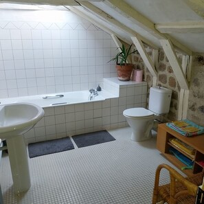 A small, tiled bathroom with a bathtub, toilet, and sink. - Guest house (Rouffiac)