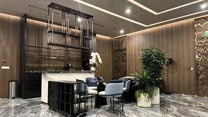 A modern reception area with a marble floor, a reception desk, seating area, and decorative plants. - Vinhomes Central Park - The Landmark (Ho Chi Minh City)