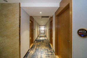 A hotel corridor with a marble wall, a patterned carpet, and a sign indicating room number 8611. - Yeste Hotel (Nanning Jiuquwan Hot Spring) (Nanning)
