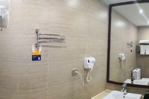 A bathroom with a sink, mirror, towel rack, and a hand dryer. - YeNanning East Railway Station Jiuquwan Hot Spring) (Nanning)