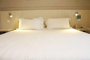 A hotel room with a large bed, two bedside lamps, and a nightstand with a telephone. - Jinjiang inn (Shanghai Chedun Film Shooting Base) (Shanghai)