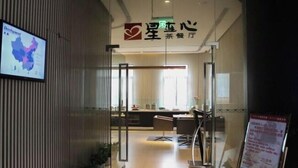 A reception area with a desk, chairs, and a glass partition. A digital screen displays a map. - Jinjiang inn (Shanghai Chedun Film Shooting Base) (Shanghai)