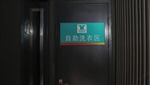 A door with a sign indicating a self-service laundry area. - Jinjiang inn (Shanghai Chedun Film Shooting Base) (Shanghai)