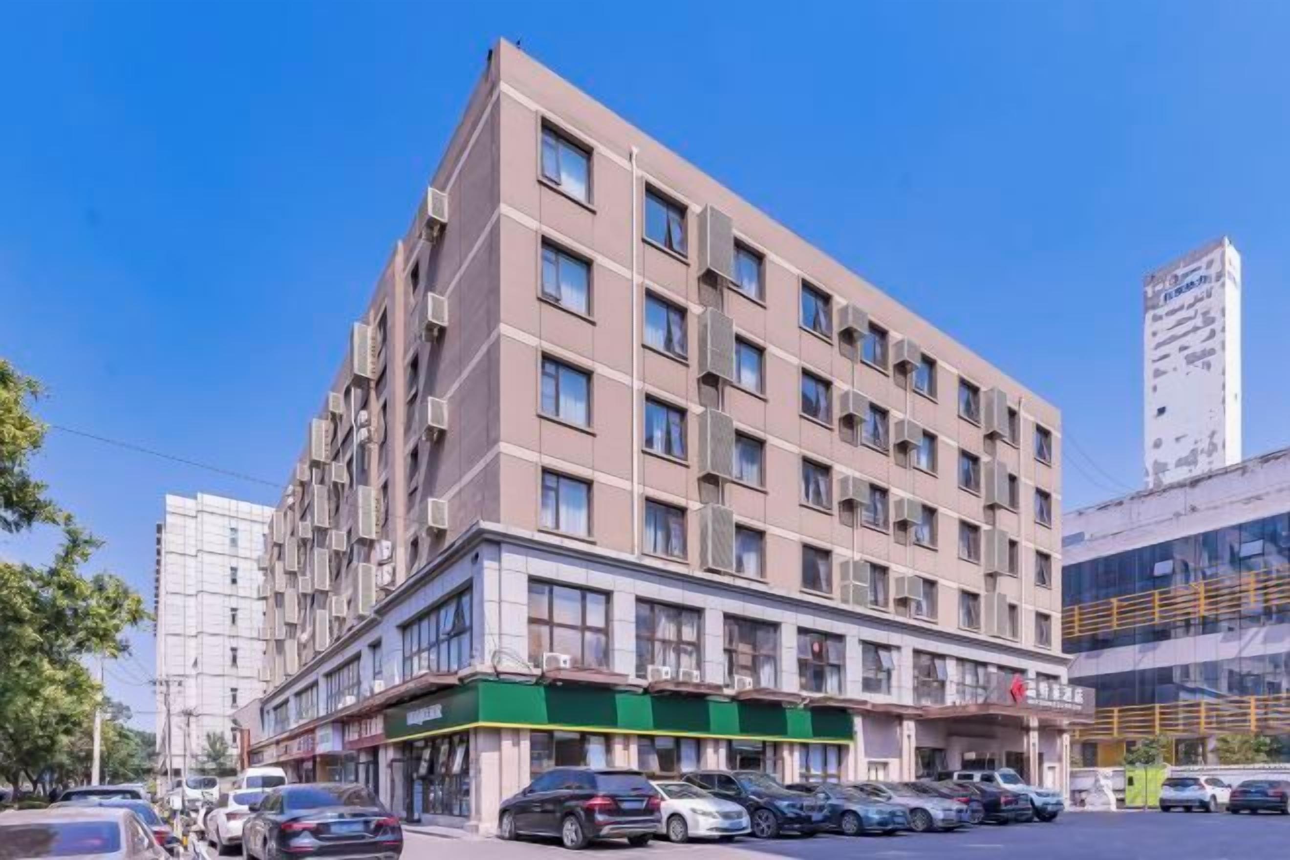 A multi-story hotel with a flat facade, large windows, and a green awning.