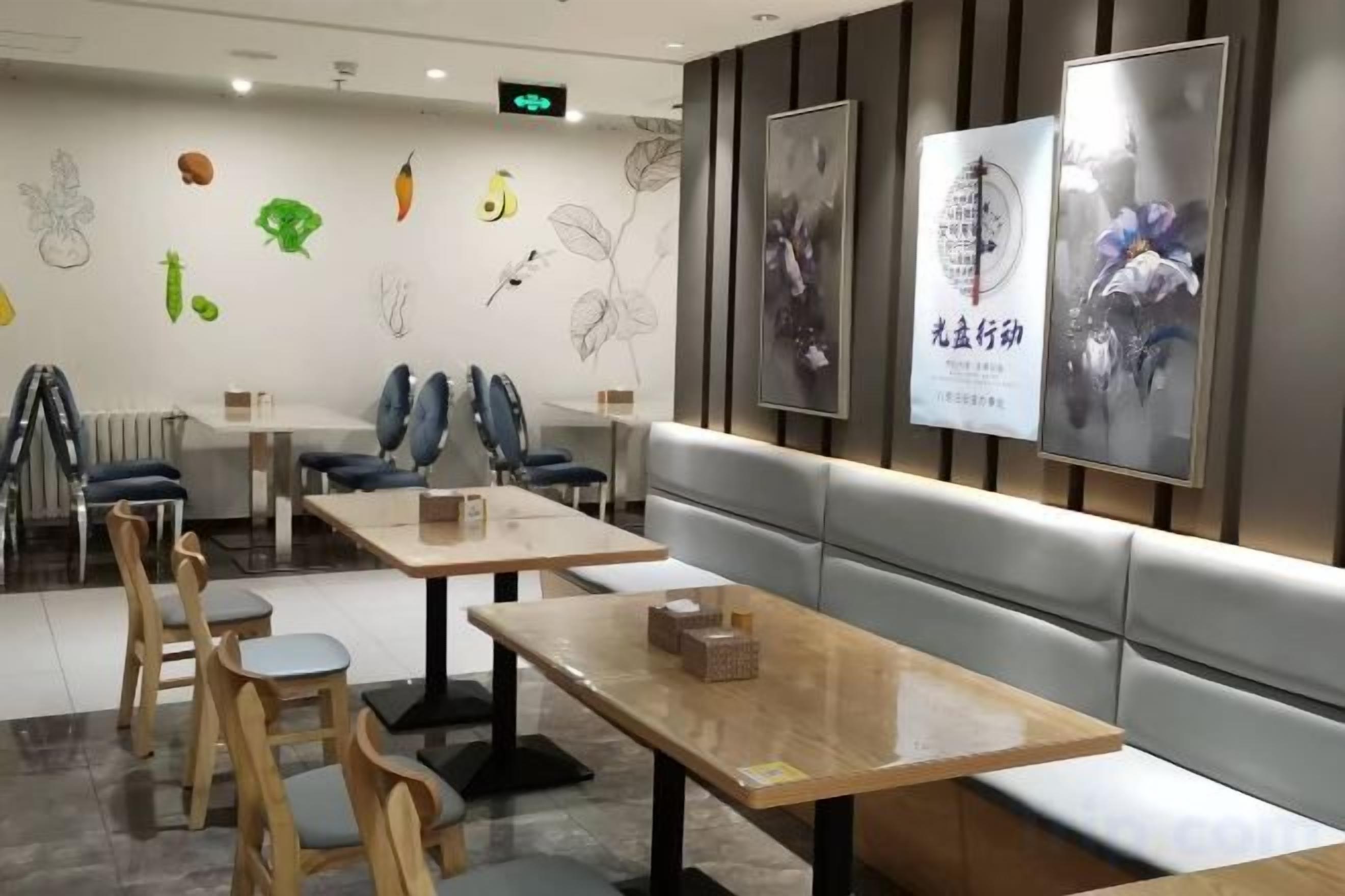 L'intérieur d'un restaurant avec des banquettes, des tables et des chaises.