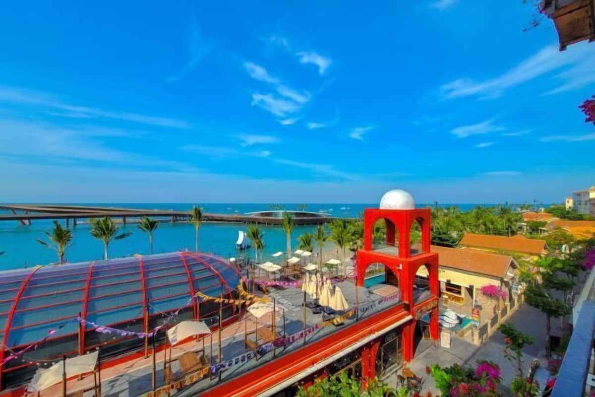 A hotel with a pool, outdoor seating, and a view of the ocean.