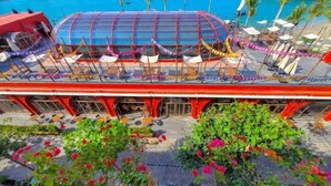 A rooftop bar with a glass enclosure, outdoor seating, and a pool in the background. - Juliet Boutique Hotel - Sunset Town (Phu Quoc Island)