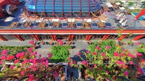 A large, modern building with a blue roof and multiple levels of outdoor seating areas. - Juliet Boutique Hotel - Sunset Town (Phu Quoc Island)