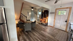 Une cuisine spacieuse avec un coin repas, un plancher en bois et un ventilateur de plafond.