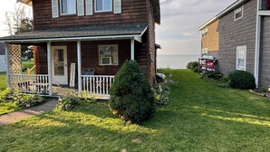 Une maison en bois à deux étages, dotée d’un porche, d’un petit jardin et d’une enseigne indiquant qu’il s’agit d’un chalet.