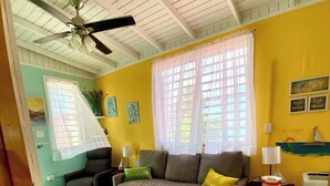 A living room with a sofa, a coffee table, and a ceiling fan. - Ocean front 2-bedroom house private Beach, pool in enchanting Rincon wifi AC (Rincon)