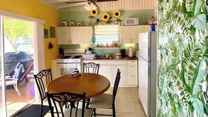 A kitchen with a wooden table and chairs, a ceiling fan, and a sign that reads "CRAB SHACK". - Ocean front 2-bedroom house private Beach, pool in enchanting Rincon wifi AC (Rincon)
