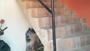 A staircase with wooden steps and a metal handrail. - Hotel Ancestral Rojas coffee (San José de Isnos)