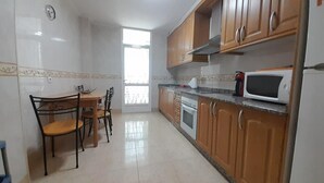 A kitchen with wooden cabinets, a microwave, and a stove.