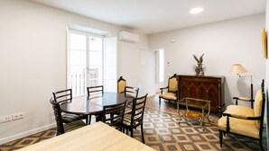 Een eethoek met een ronde tafel en stoelen, een houten kast en een lamp.