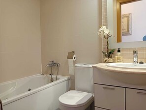 A bathroom with a bathtub, toilet, and sink. - 3 Bed Flat - Sleeps 6 - Pool - Garden - Parking (Vilagarcia de Arousa)