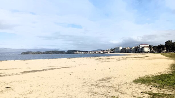 A beach with a clear sky, a sandy shore, and buildings in the background. - Piso en el Centro Para 6 Personas en Vilagarcia (Vilagarcia de Arousa)