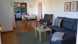 A living room with a sofa, a coffee table, and a dining area with a table and chairs. - Herdade do Castanheiro nur Wenige Min. von Lagos in Traumhafter Ruhiger Lage (Bensafrim/ Lagos)