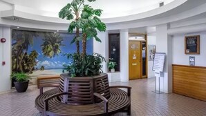 A lobby with a central seating area, a large mural, and a reception desk. - Charming cozy condo in marvelous Honolulu with WiFi (Honolulu)