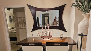A dining table with two chairs, a decorative ship model, and a clock. - Luxury 2-bedroom waterfront condo with parking, in sunny South Tampa (Tampa)