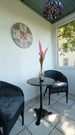 Enjoy a peaceful retreat in this serene patio area with a round table and two comfortable chairs.