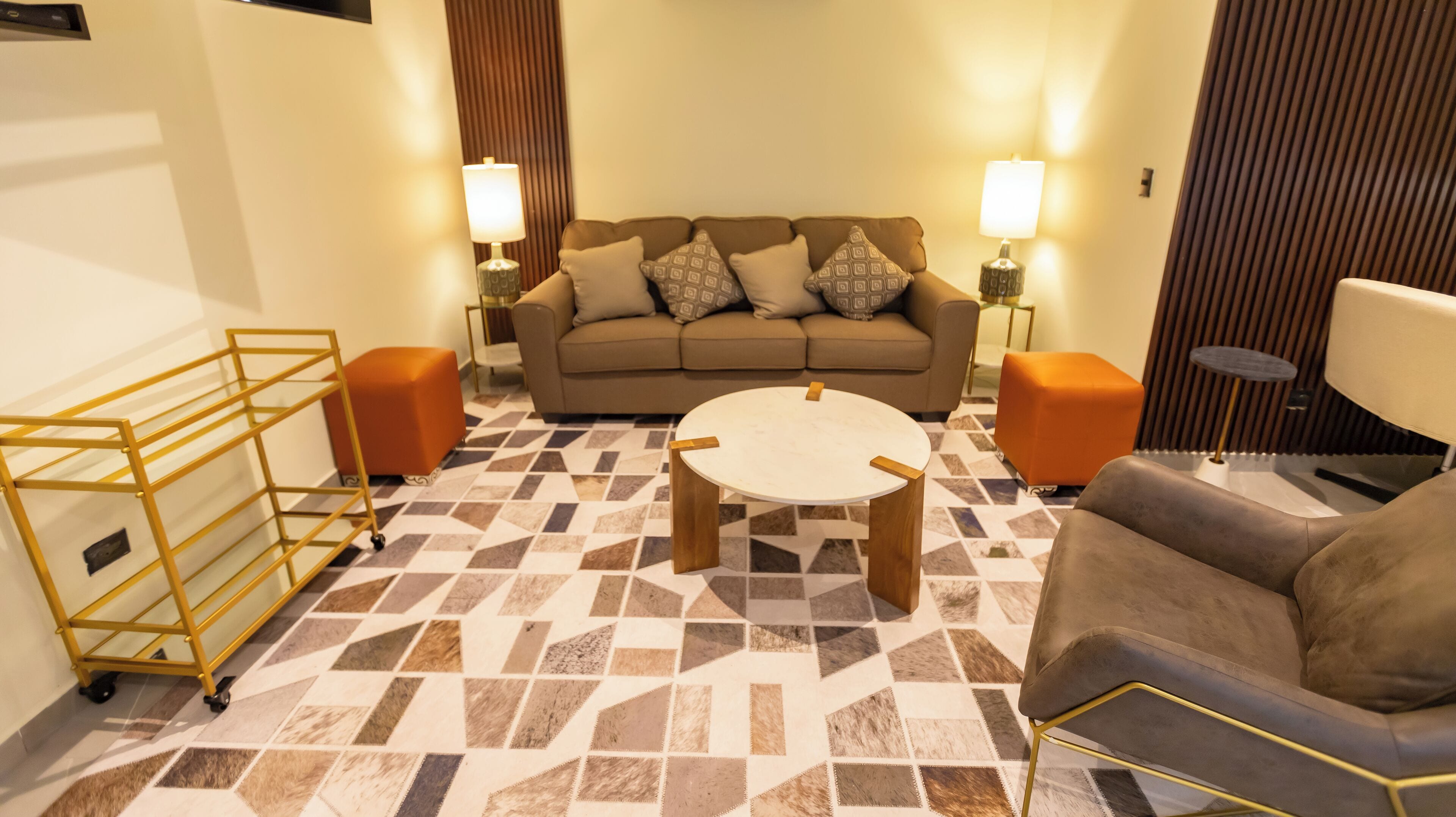 Un salon moderne avec un canapé, une table basse et deux lampes.