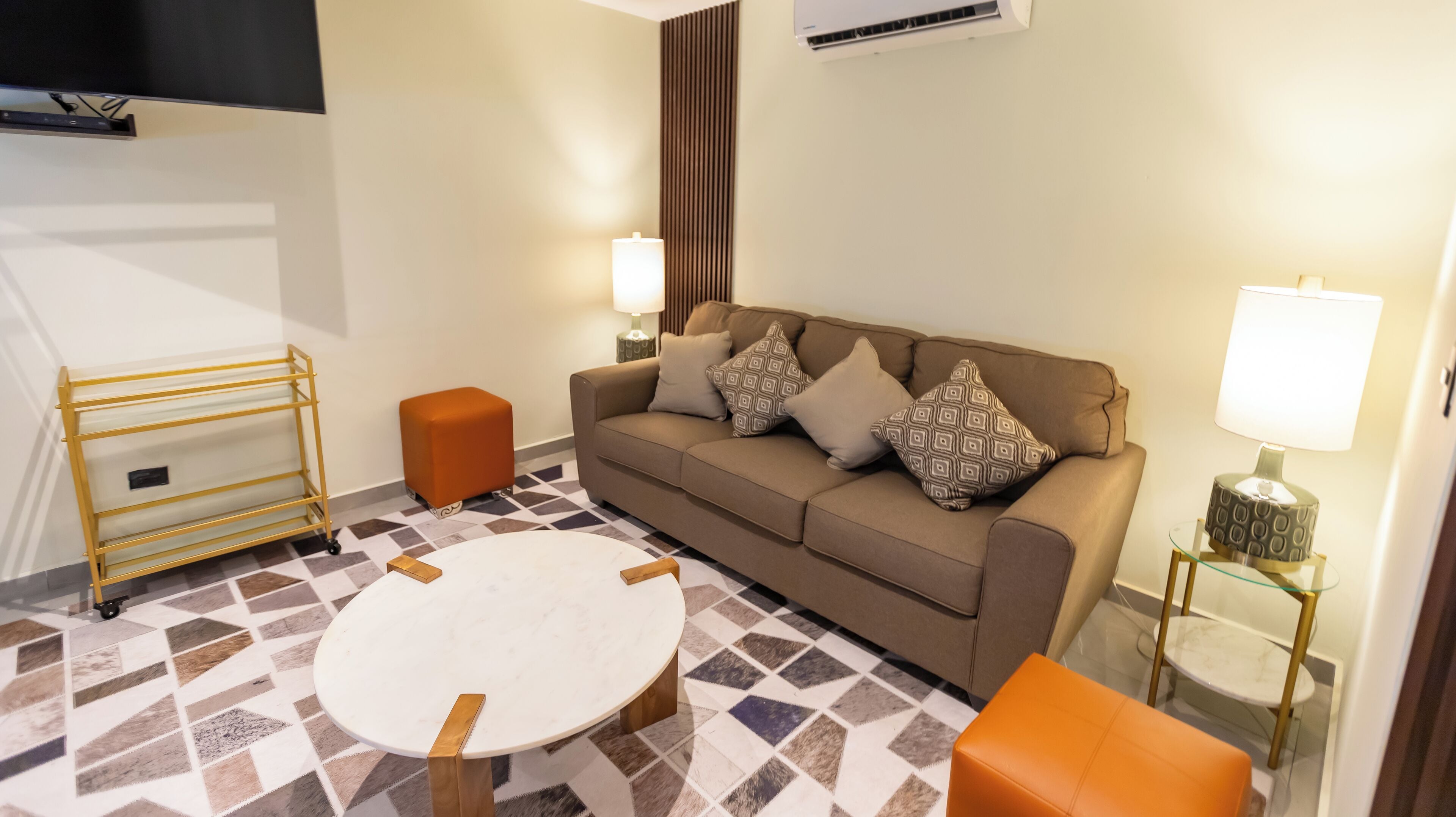 Un salon moderne avec un canapé, une table basse et un téléviseur.