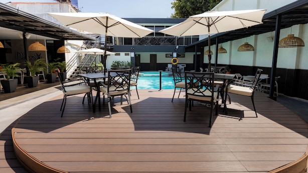 Ein Poolbereich mit Sitzgelegenheiten und Sonnenschirmen.