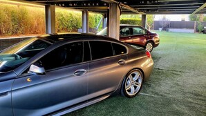 A covered parking area with two cars parked under a structure. - Indoor and Outdoor Living (Los Angeles)