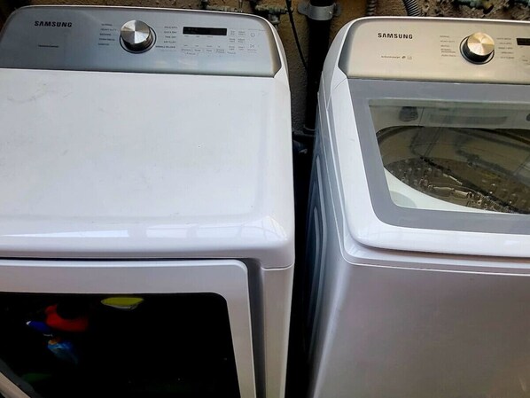 Two white Samsung washing machines side by side.