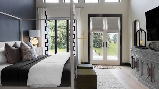 Une chambre à coucher moderne avec un grand lit, une table de chevet, une lampe et un téléviseur.