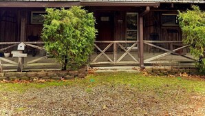 A rustic wooden building labeled "Peaceful Pines Lodge" with a porch and a welcome sign.