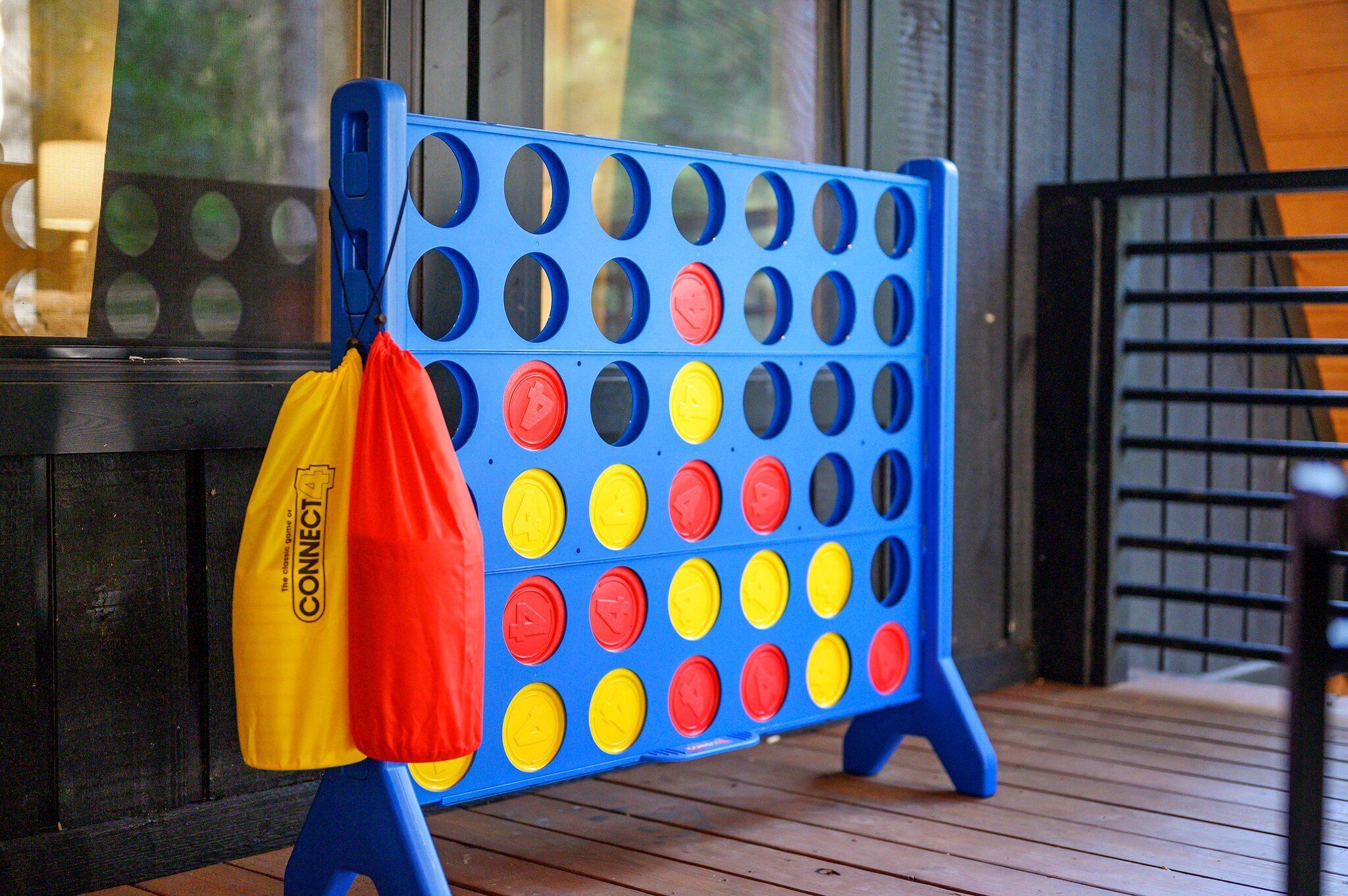 A blue and yellow game board with a yellow and red bag nearby.