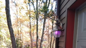 A house with a garage door, a porch with a potted plant, a street lamp, and a 'Happy Fall' sign. - Charming 2-bedroom B&B in Honey Brook with WiFi, fitness room 
bed and breakfast (Honey Brook)