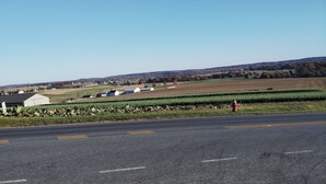 A rural road with a clear sky, fields, and a few buildings in the distance. - Charming 2-bedroom B&B in Honey Brook with WiFi, fitness room 
bed and breakfast (Honey Brook)